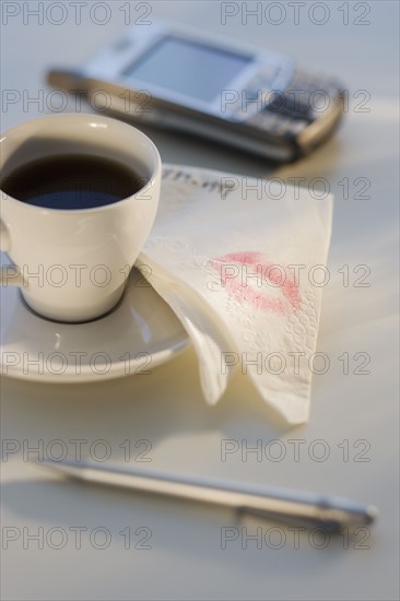 Lipstick on napkin next to coffee.