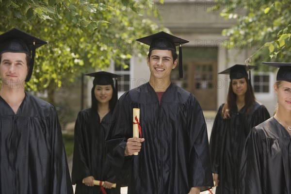 Group of college graduates holding diplomas.