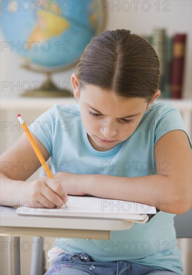 Girl writing in classroom.