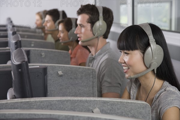 College students wearing headsets in computer lab.