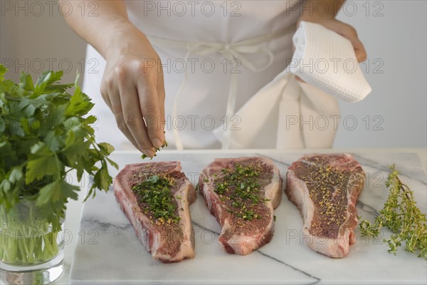 Chef seasoning pieces of meat.