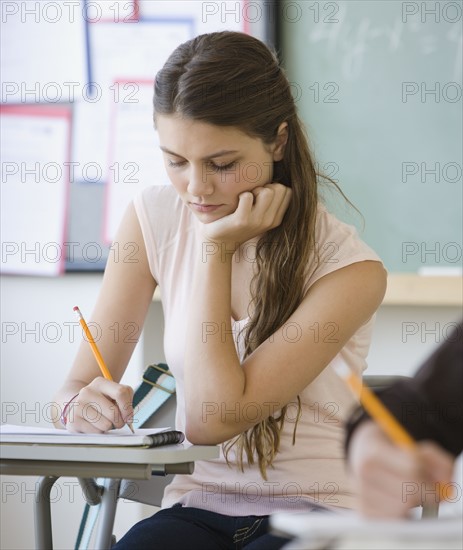 Girl writing in classroom.