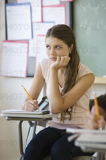 Girl writing in classroom.