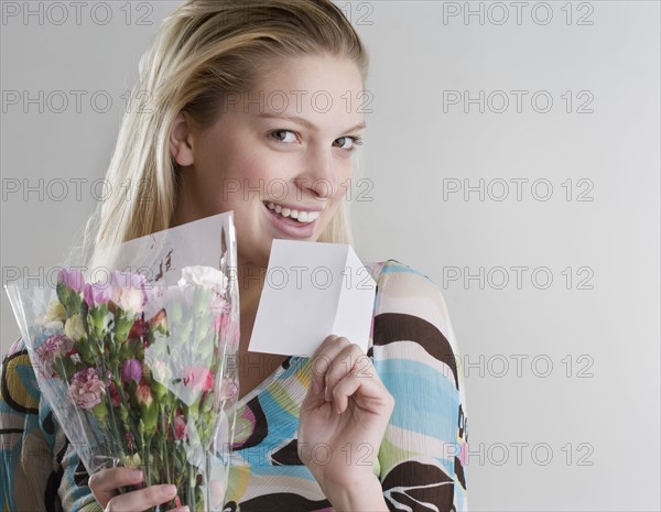 Woman holding flowers and card. Date : 2006