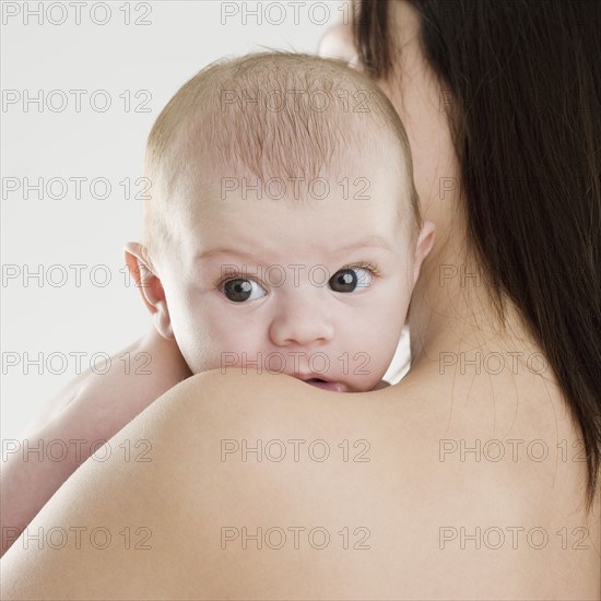 Baby looking over mother’s shoulder. Date : 2006