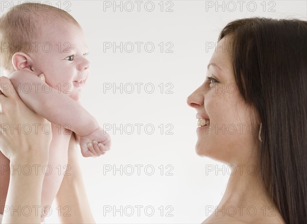 Studio shot of mother smiling at baby. Date : 2006