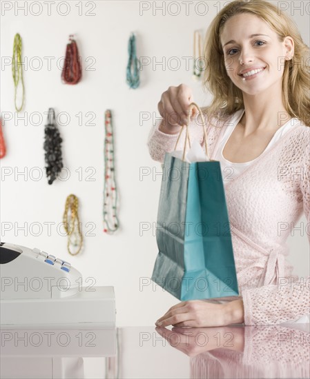 Saleswoman next to register at boutique. Date : 2006