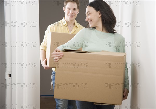 Couple carrying boxes in new house. Date : 2006