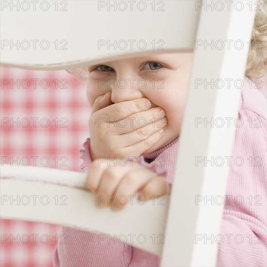 Portrait of child looking through a chair. Date : 2006