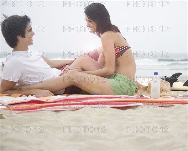 Couple sitting on blanket at beach. Date : 2006