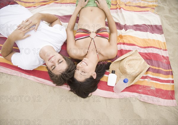 Couple laying on blanket at beach. Date : 2006