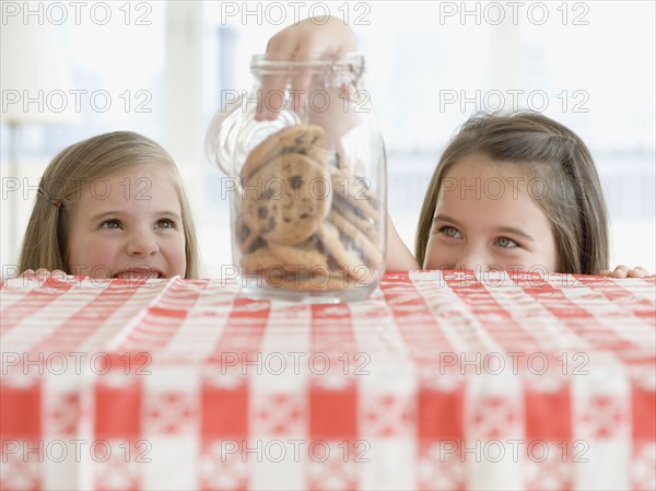 Sisters taking cookies from jar. Date : 2006