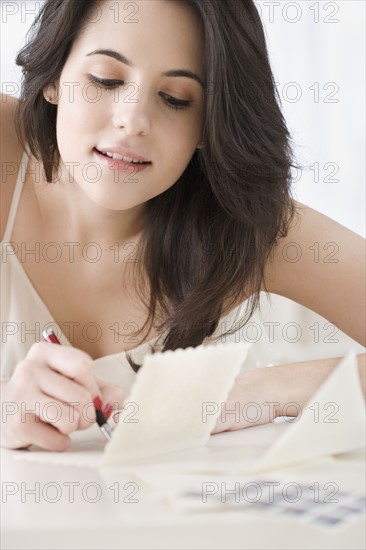 Woman writing cards at table. Date : 2007