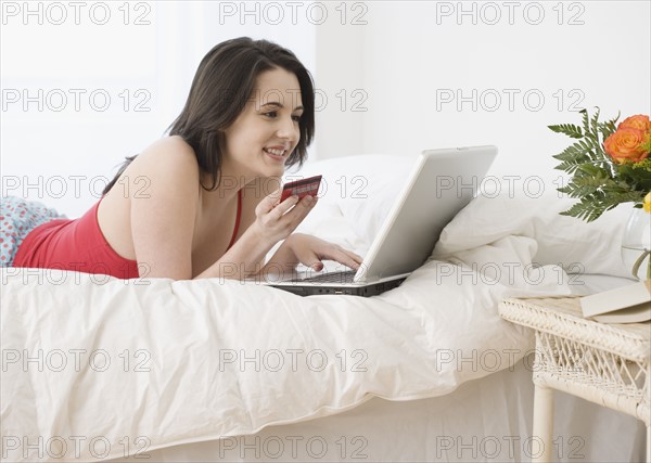 Woman shopping online in bed. Date : 2007