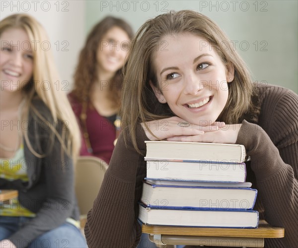 Female student leaning on stack of books. Date : 2007