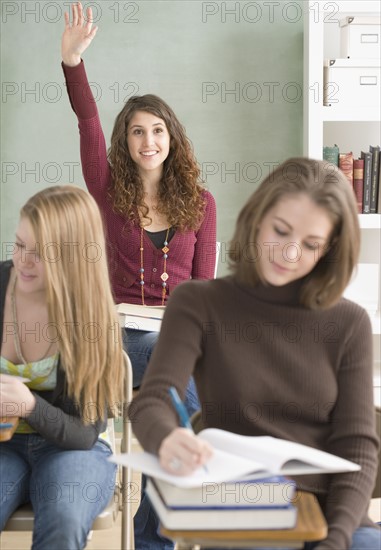 Female student raising hand in classroom. Date : 2007