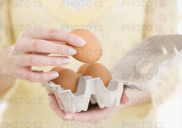 Woman holding carton of eggs. Date : 2007