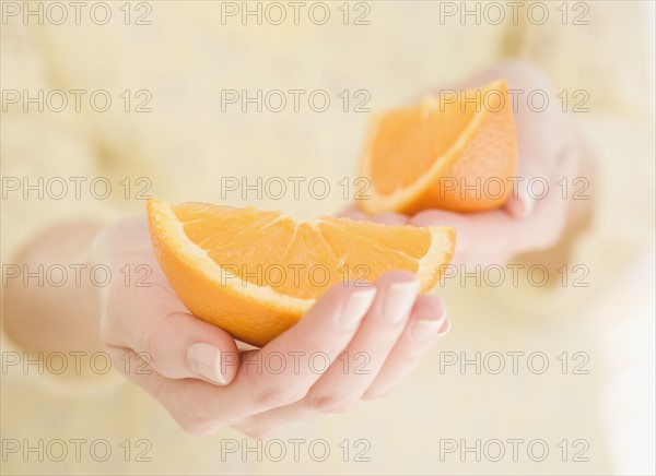 Woman holding orange wedges. Date : 2007