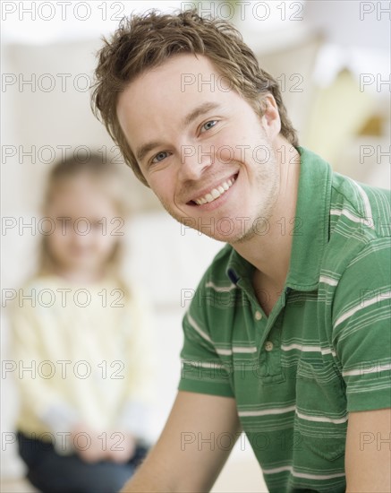 Father smiling with daughter in background. Date : 2007