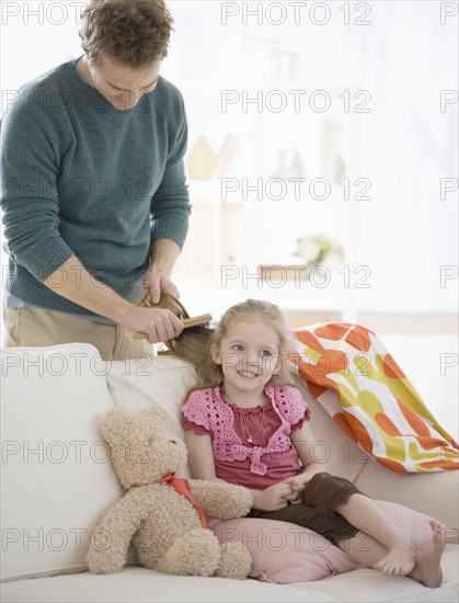 Father brushing daughter’s hair. Date : 2007