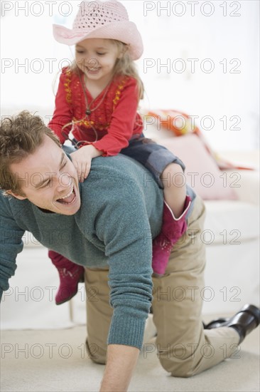 Father and daughter playing in livingroom. Date : 2007