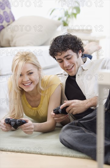 Couple playing video games on floor. Date : 2007