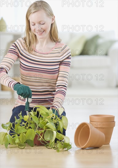 Woman putting plant in pot. Date : 2007