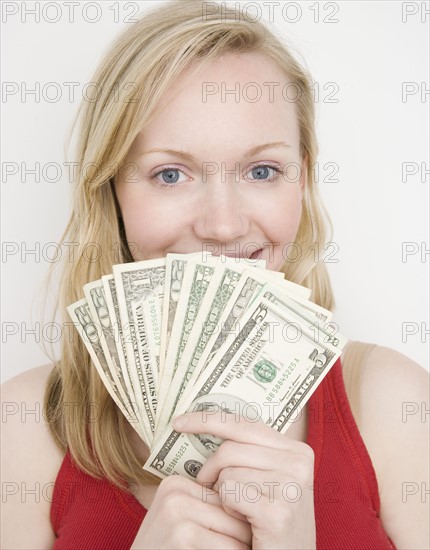 Woman holding fanned out money. Date : 2007