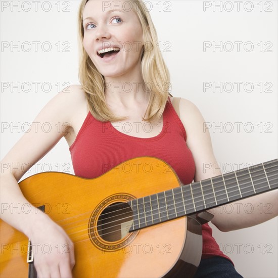 Woman paying acoustic guitar. Date : 2007