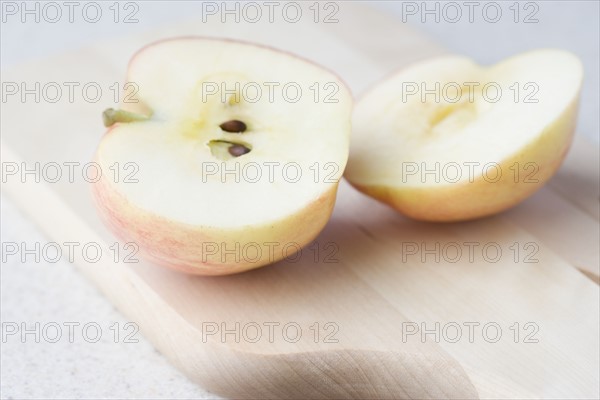 Halved apple on cutting board. Date : 2006