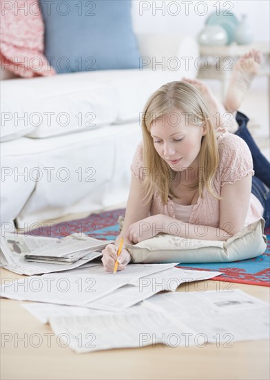 Woman reading newspaper classifieds. Date : 2007