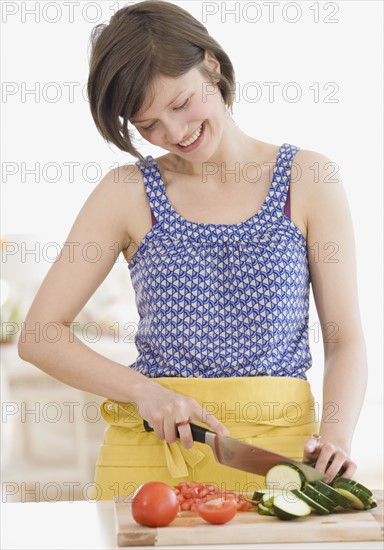 Woman chopping vegetables in kitchen. Date : 2007