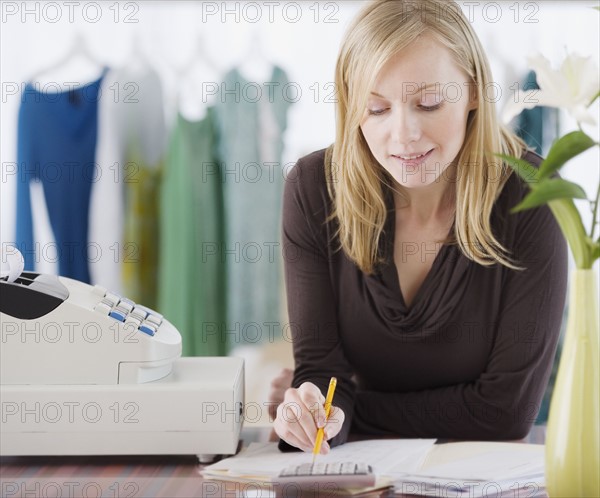 Clothing store sales clerk doing paperwork. Date : 2007