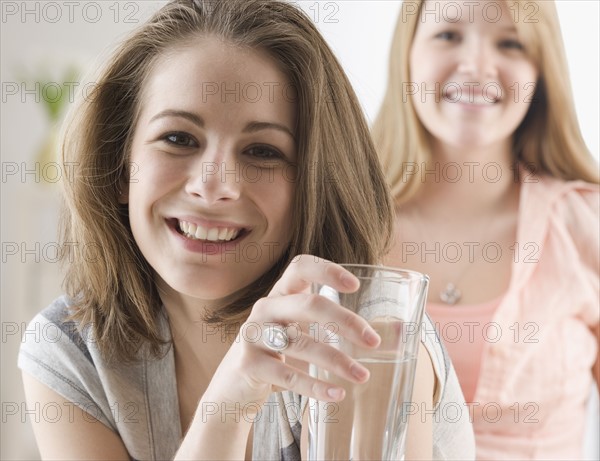 Portrait of teenage girl holding glass of water. Date : 2007