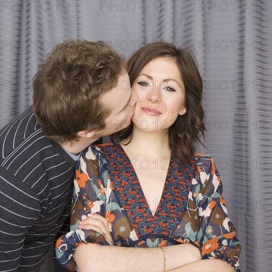 Man kissing girlfriend on cheek. Date : 2007