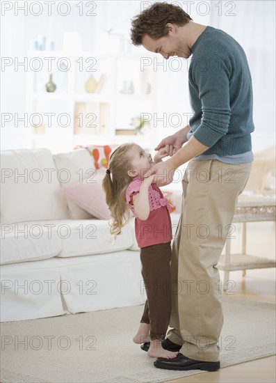 Girl dancing on father’s feet. Date : 2007