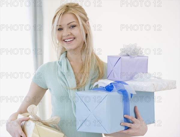 Woman holding stack of gifts. Date : 2007