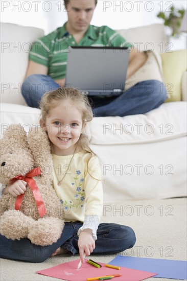 Father and daughter relaxing in livingroom. Date : 2007