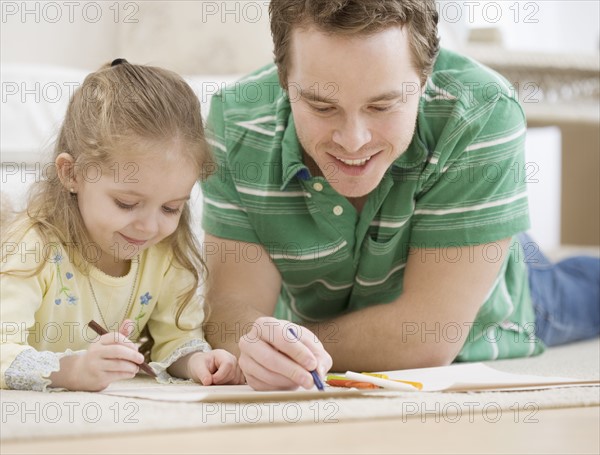 Father and daughter coloring on floor. Date : 2007
