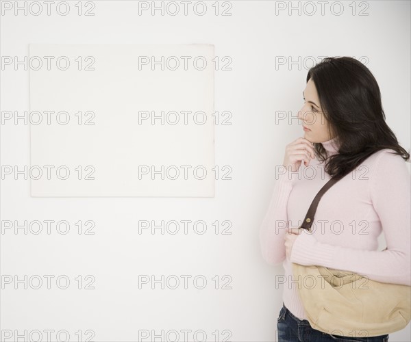 Woman looking at blank picture on wall. Date : 2007
