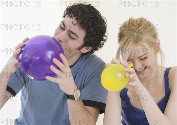 Couple blowing up balloons. Date : 2007