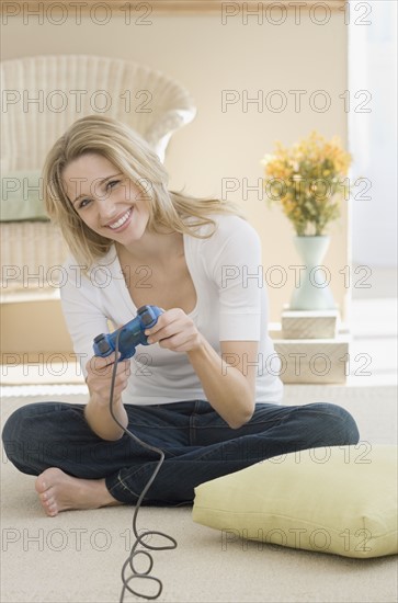 Woman playing video games on floor. Date : 2007