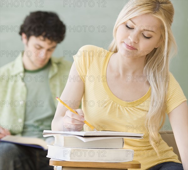 Woman writing at desk in classroom. Date : 2007