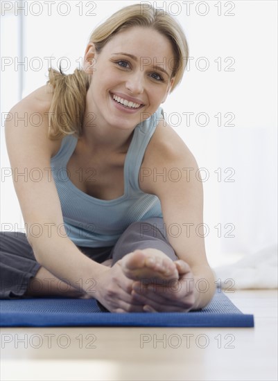 Woman stretching on yoga mat. Date : 2007