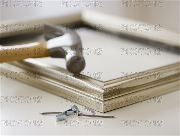 Close up of hammer, nails and picture frame. Date : 2006