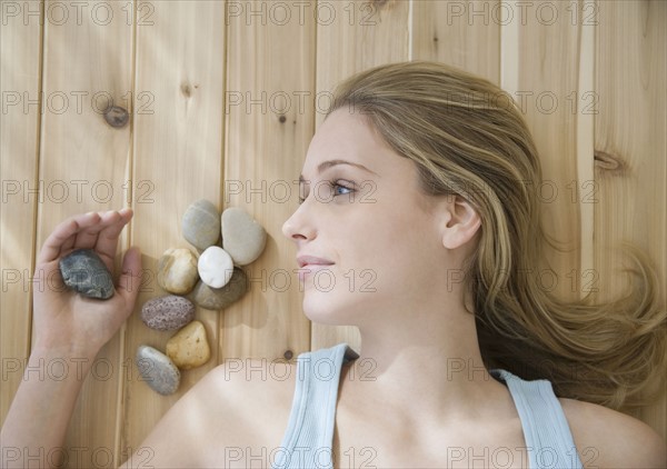 Woman laying on floor next to stones. Date : 2007