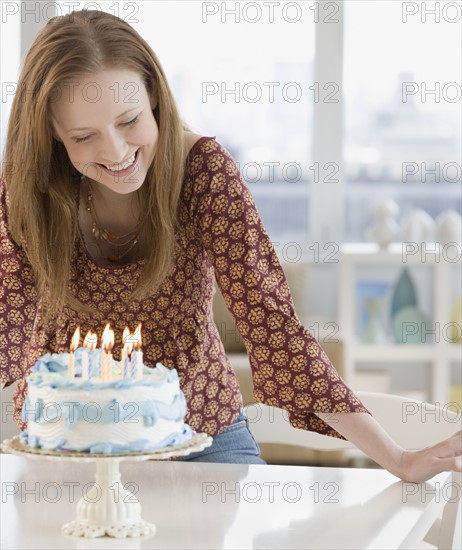 Woman smiling at birthday cake. Date : 2006