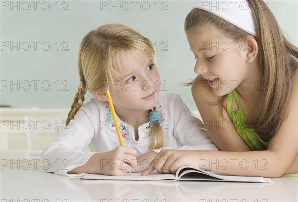 Girl helping classmate at desk. Date : 2006