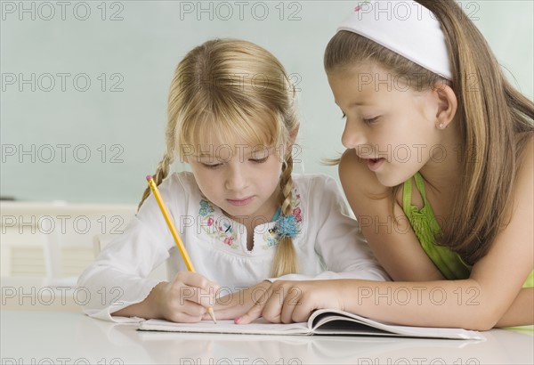 Girl helping classmate at desk. Date : 2006