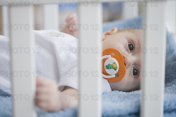 Baby in crib with pacifier. Date : 2007